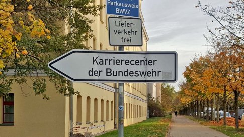 Ein weißer Straßenschildpfeil zeigt den Weg zu Karrierecenter der Bundeswehr.